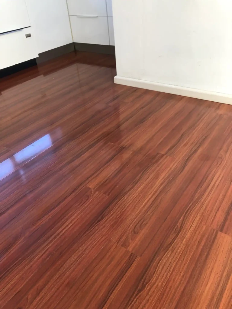 Laminate floor restored to a smooth, scratch-free surface after repair.