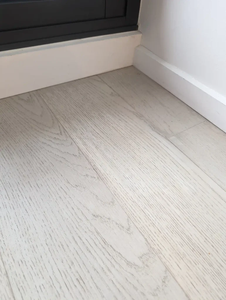 Repaired water-damaged floor near skirting board