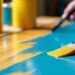 Person painting a wooden benchtop with a brush.