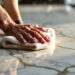 Person polishing a marble benchtop with a cloth.