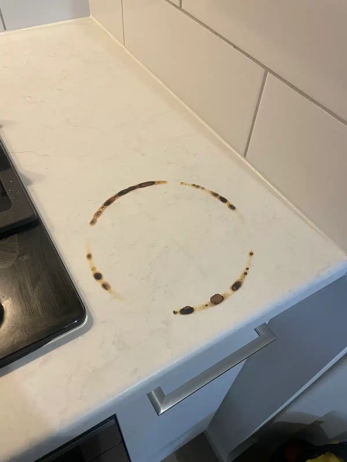 Stone-look benchtop with a circular burn ring before repair