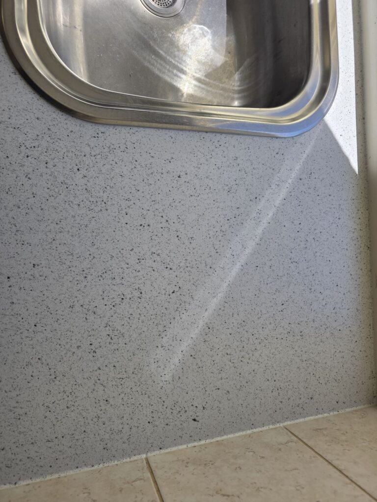 Close-up of the same sink area after benchtop resurfacing, fresh speckled finish, Hillside