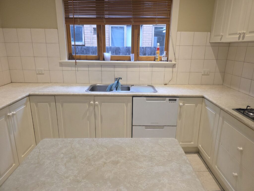 Worn beige laminate kitchen benchtop and island before resurfacing, Malvern
