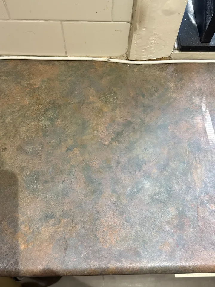 The same benchtop after the scorch was repaired and the pattern painted back in