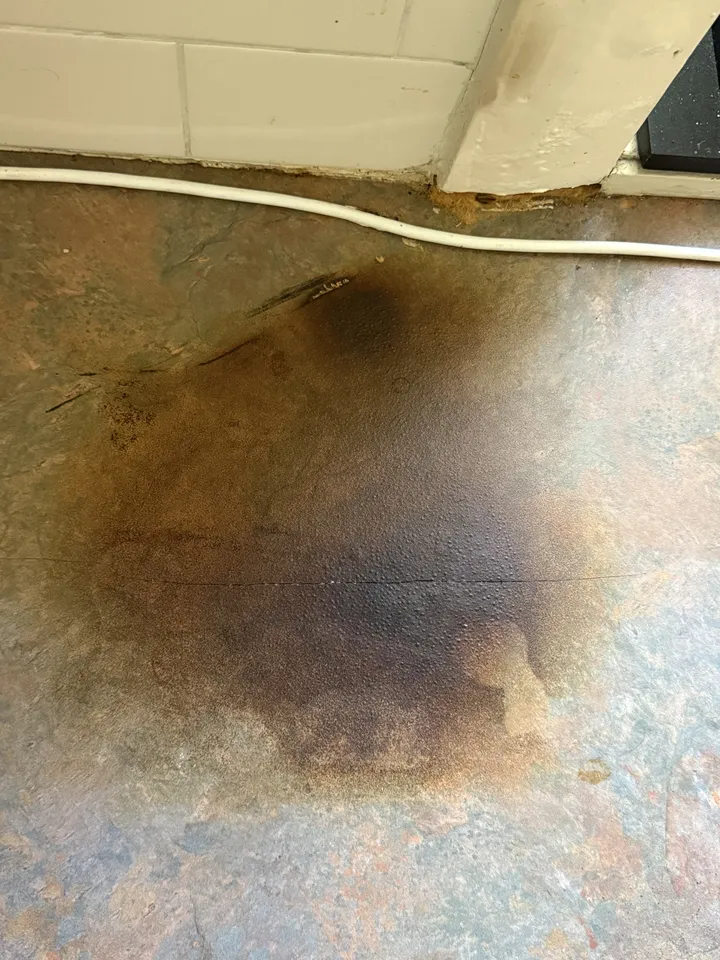 Patterned laminate kitchen benchtop with a large dark scorch mark across the top