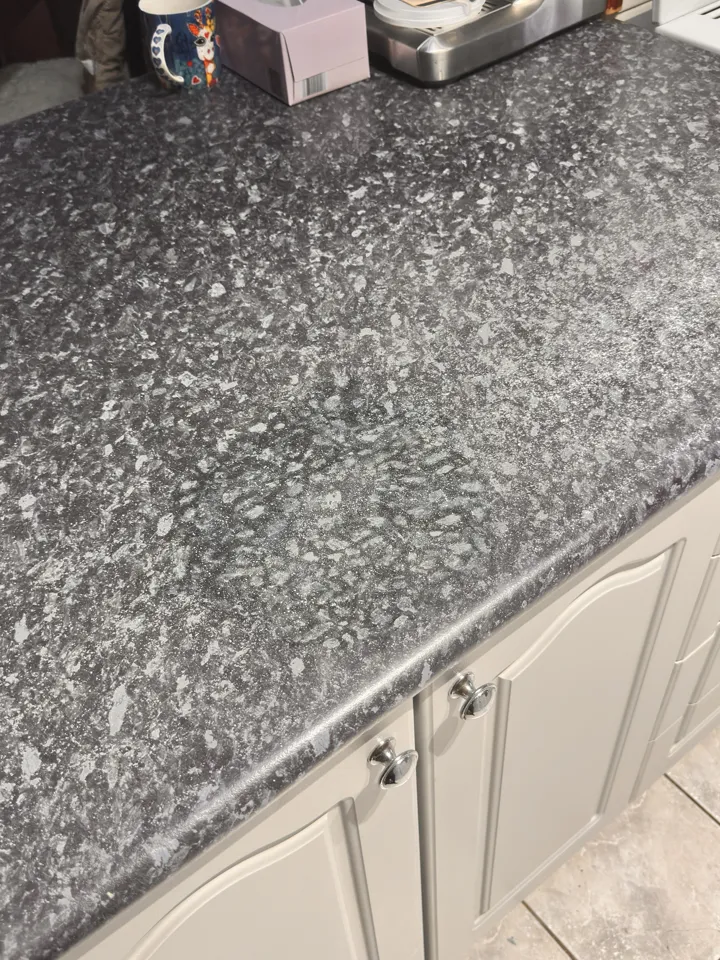 The same benchtop after the ring burn was filled and the dark granite pattern painted back in